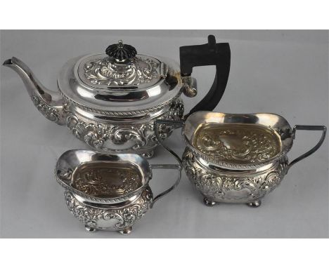 An Edward VII silver three piece tea service, by Joseph Gloster, Birmingham 1903, of ovoid form, having repousse embossed flo