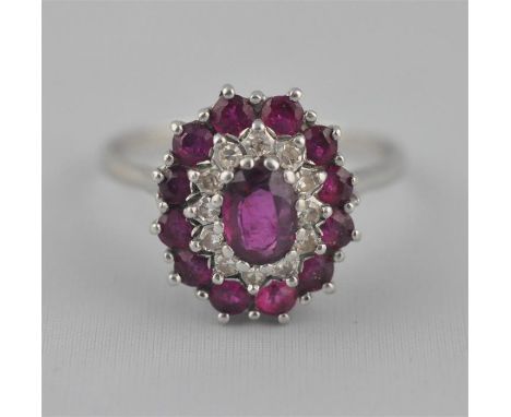 A platinum, ruby and diamond cluster ring, set central oval brilliant cut ruby surrounded round cut diamonds with&nbsp;round 