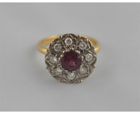 A gold, ruby and diamond cluster ring, mixed yellow and white metal flower form mount set central ruby (approx. 0.5 carat) su