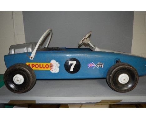 A VINTAGE PRESSED STEEL PEDAL CAR, in the form of a Formula 1 Racing Car, c. Late 1960's or early 1970's, playworn condition,