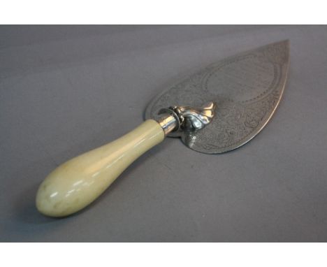 A LATE VICTORIAN SILVER TROWEL, the heart shaped blade engraved with foliate decoration surrounding a presentation inscriptio