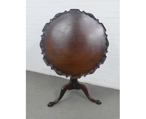 19th century mahogany pie crust table, the tilt top with carved rim, on a reeded baluster column and tripod legs,  70 x 84cm 