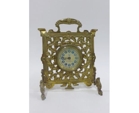 Clock in a pierced brass frame by the British United Clock Company, Reg No. 189583, 19cm 