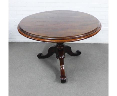 Victorian mahogany table, the oval top with a moulded edge on a baluster column and tripod supports terminating on ceramic ca