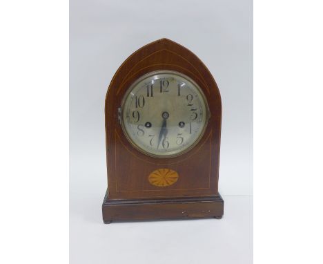 Mahogany cased mantle clock, the arched top over a silvered dial with Arabic numerals, raised on four brass bun feet, 33cm 