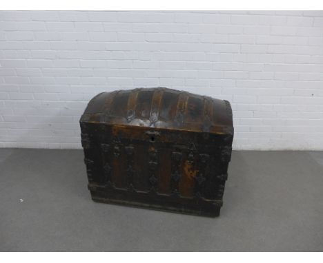 An antique oak and iron bound trunk with a domed top, the strap work with engraved shell pattern, with leather handles to the