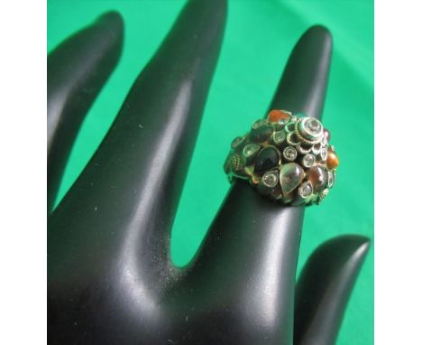 A multi-gem set bombe form cluster ring, the cabouchon stones including ruby, sapphire and tigers eye with filigree mount, ma