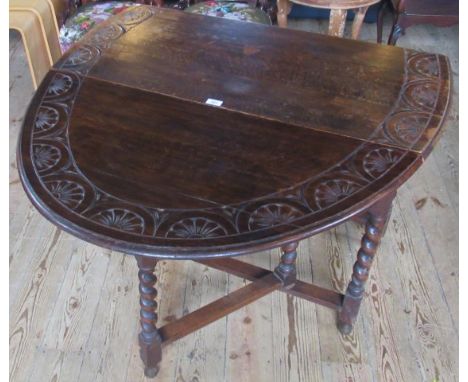 An Edwardian carved oak barley twist gate-leg drop flap dining table.