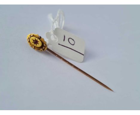 A 15ct gold stick pin set with a garnet 