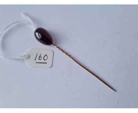 A gold cabochon garnet stick pin