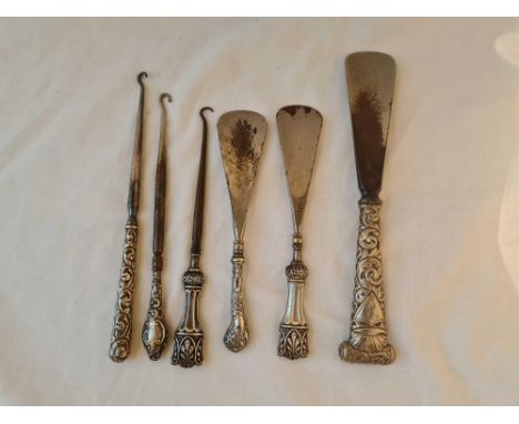 A group of six silver handled button hooks and shoe horns