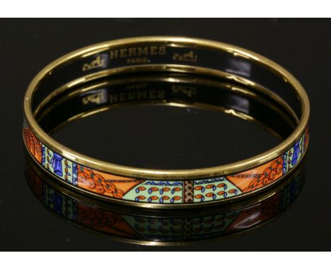 An Hermès narrow orange enamel gold-plated bangle, with printed abstract design, stamped 'Hermès Paris, Made in Austria'