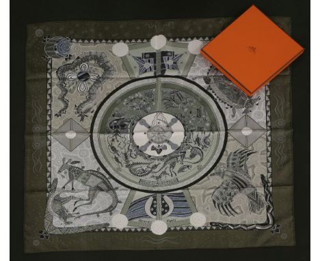 An Hermès silk scarf,'Reve Australie', designed by Zoe Pauwels, dark khaki green ground with printed Aboriginal design, in bo