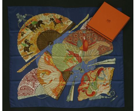 An Hermès silk scarf,'Brise de Charme', designed by Julia Abadie, navy blue ground with a printed fan design, with ribbon, in