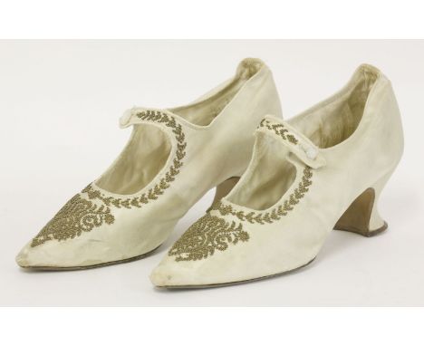 A pair of cream silk ladies' shoes,19th century, the silk embellished with applied gold seed beads and sequins to toe and foo