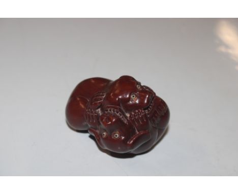 A carved wooden Netsuke in the form of dogs