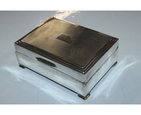 A silver engine turned and wooden lined decorated cigarette box