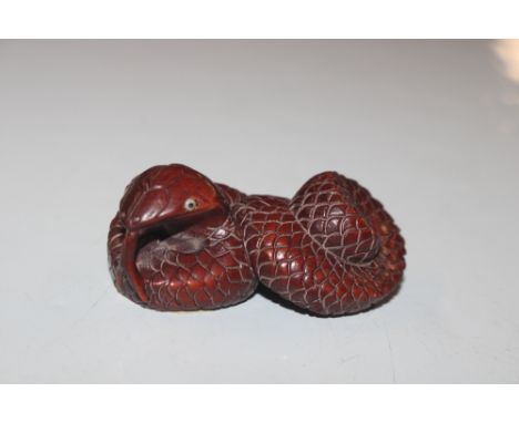 A carved wooden Netsuke in the form of a snake 
