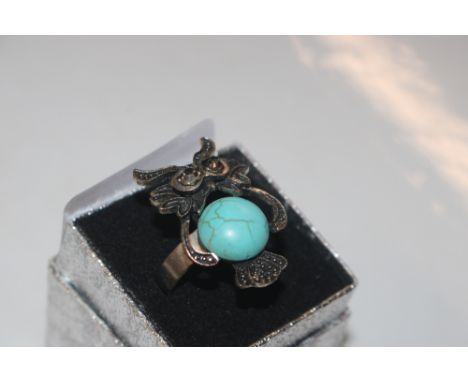 A ring in the form of an owl decorated with turquoise coloured stone 