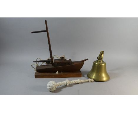 A Novelty Table Lamp in the Form of a Carved Wooden Boat Together with a Brass Wall Mounting Ships Bell 