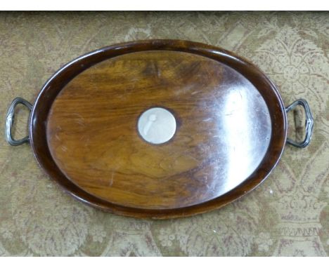 AN OVAL WALNUT SILVER MOUNTED TWO HANDLED ART DECO TRAY. APPROXIMATE MEASUREMENT 59.5cms x 37cms.