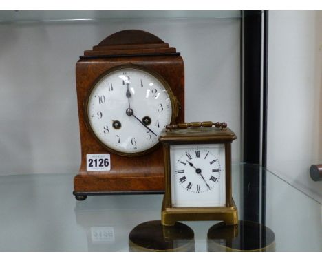 A BRASS CASED CARRIAGE CLOCK AND A WALNUT MANTLE CLOCK.