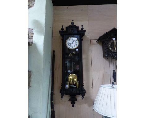 A VICTORIAN VIENNA WALL CLOCK WITH EBONISED CASE, UNSIGNED TWO PART ENAMEL DIAL COMPLETE WITH TWO WEIGHTS,  PENDULUM AND KEY.