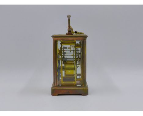 AN EARLY 20th.C.BRASS CASED CARRIAGE CLOCK WITH TWO TRAIN GONG STRIKE MOVEMENT, WHITE ENAMEL DIAL WITH ROMAN NUMERALS.   H.18