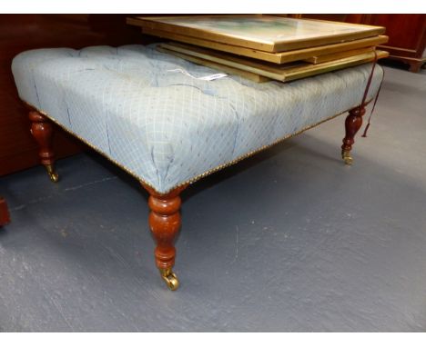A BUTTON UPHOLSTERED MAHOGANY REGENCY STYLE LARGE STOOL WITH BRASS CASTORS.   W.104cms.