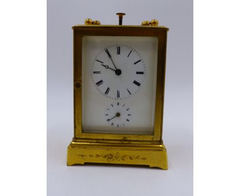 A SMALL GILT BRASS CASED DRESSING TABLE OR BEDSIDE CLOCK WITH ALARM AND PUSH 1/4 REPEAT BELL STRIKE MOVEMENT.   H.10cms.