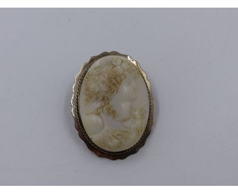 A WHITE CARVED PORTRAIT CAMEO SET IN A SILVER STAMPED FLUTED BROOCH MOUNT. APPROXIMATE MEASUREMENTS 5.6 x 4.3cms. TOGETHER WI