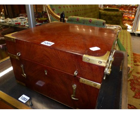 AN ANTIQUE BRASS BOUND MAHOGANY DECANTER BOX WITH FITTED INTERIOR TO INCLUDE TWO DECANTERS AND BRASS CARRYING HANDLES.