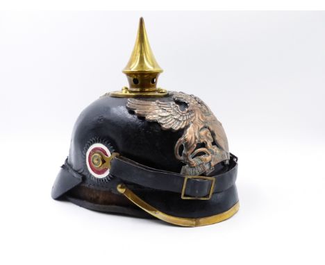 A GERMAN PICKLEHAUBE HELMET WITH BLACK LEATHER SKULL AND SPIKE FINIAL AND WINGED GRIFFIN HELMET PLATE. ALSO TO INCLUDE A CLOT