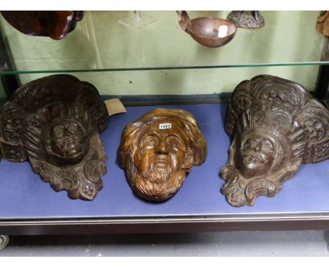 A PAIR OF EARLY CARVED OAK WALL BRACKETS, EACH DECORATED WITH THE FACE OF A MAN WITHIN SCROLLWORK TOGETHER WITH A PORTRAIT MA