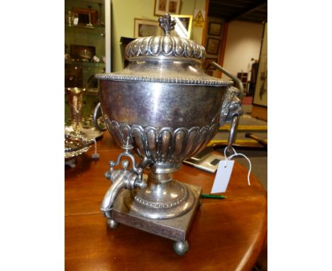 A 19TH CENTURY SHEFFIELD PLATED TEA URN ON SQUARE FORM BASE AND BUN FEET AND WITH LION MASK RING HANDLES