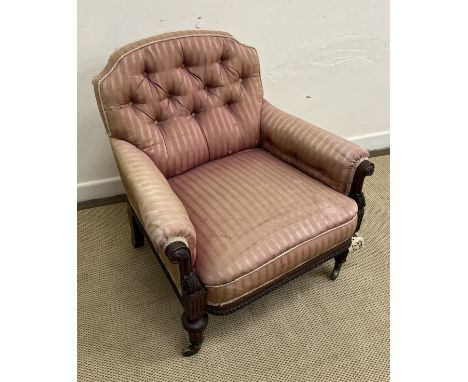 A Victorian button back salon chair with carved show frame raised on turned, ringed and fluted front legs to brass caps and c