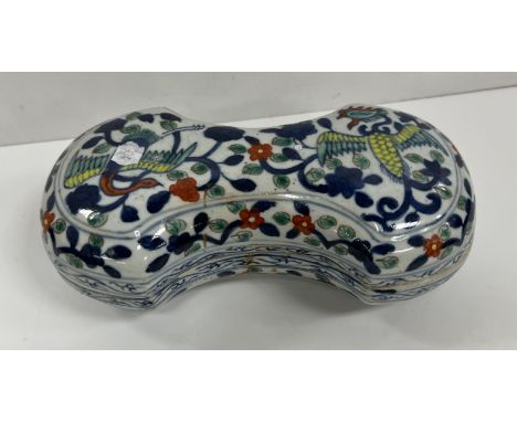 A 19th Century Chinese polychrome decorated "Ingot" box, decorated with exotic birds amongst foliage, raised on a shaped foot