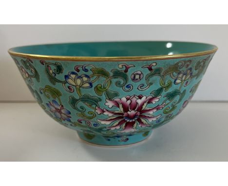 A Chinese turquoise ground rice bowl with plain interior and gilt rim, over a main body decorated with scrolling foliage and 