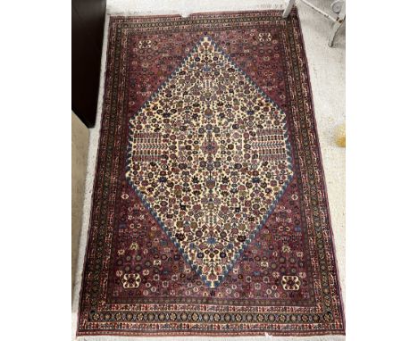A fine Persian carpet, the central panel set with lozenge shaped medallion and all over stylised foliate decoration on a crea
