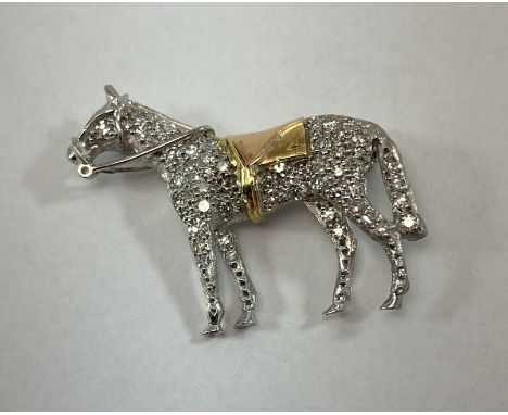 An 18 carat white gold and pavé diamond set horse brooch with yellow metal saddle No'd 4, 7.2 g, 3 cm x 2.6 cm CONDITION REPO