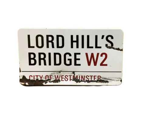 An enamelled steel street sign for Lord Hills Bridge W2, City of Westminster with iconic black and red sans serif lettering f