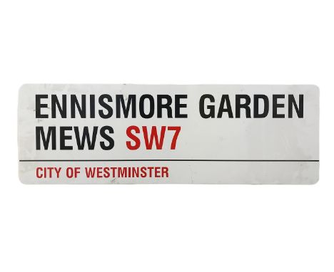 An enamelled steel street sign for Ennismore Gardens SW7, City of Westminster with iconic black and red sans serif lettering 