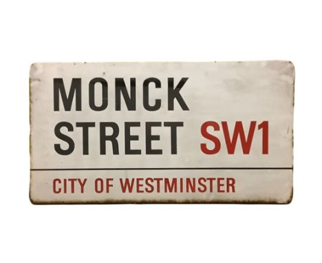An enamelled steel street sign for Monck Street SW1, City of Westminster with iconic black and red sans serif lettering first