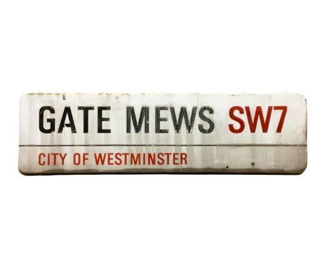 An enamelled steel street sign for Gate Mews SW7, City of Westminster with iconic black and red sans serif lettering first cr