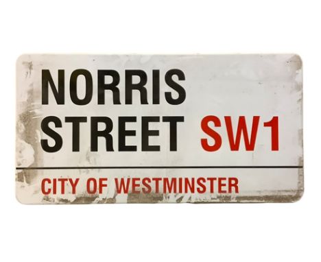An enamelled steel street sign for Norris Street SW1, City of Westminster with iconic black and red sans serif lettering firs