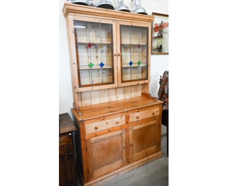 A vintage waxed pine dresser, the raised back with leaded and stained glass doors on base with two drawers and panelled cupbo