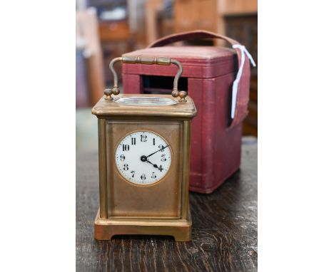 A brass carriage clock, 14.5 cm high, in red leather case 
