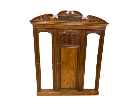 Victorian mahogany triple wardrobe, the pediment relief carved with urn and linen swags, the central panelled door carved wit