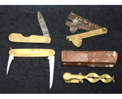 A set of cased brass sovereign scales; a Goergian three blade fleam; two brass penknives