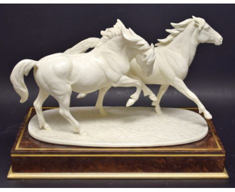 A Royal Worcester model galloping ponies, glazed in white, printed mark in gold, plinth base (faults)